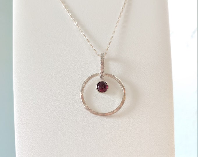 Garnet gemstone in bezel on hammered sterling silver circle.  Sterling chain.  Various lengths available