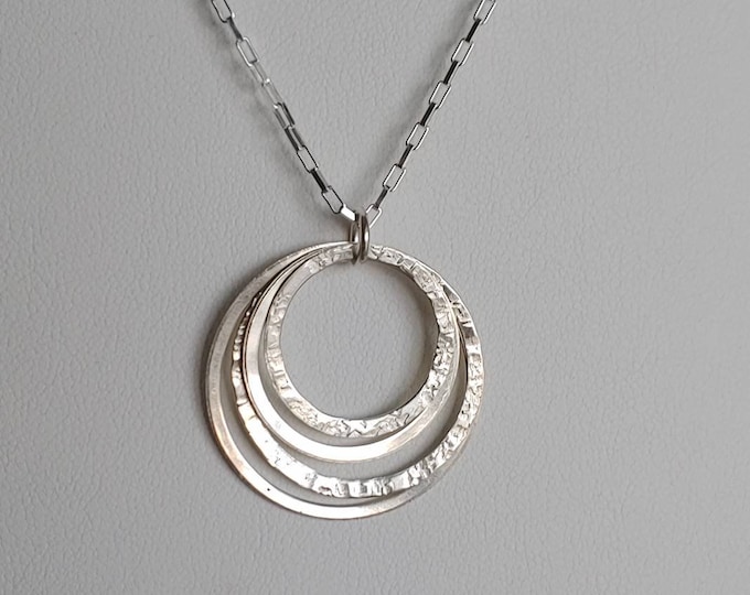 Nesting sterling circles.  Set of four textured and satin circles suspended from sterling silver jump ring and 20" sterling chain.