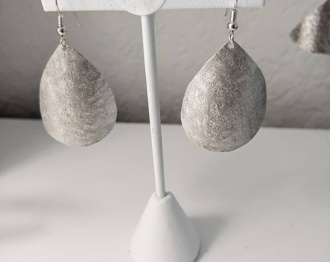 Sterling raw silk textured teardrop earrings dangle from french wires.