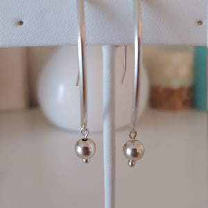 Seamless ball dangle earrings.  Balls hang from curved sterling silver tubes with self made earwires.  Lightweight,