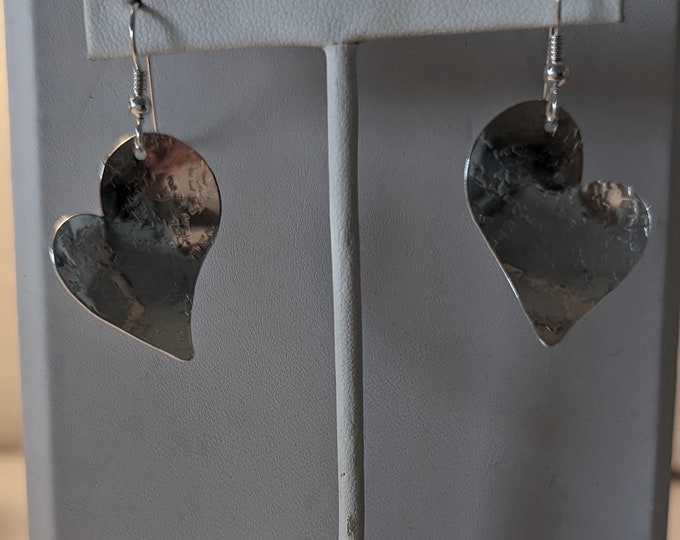 Sterling raw silk textured small hearts dangle from french wires.  Slight concave form.