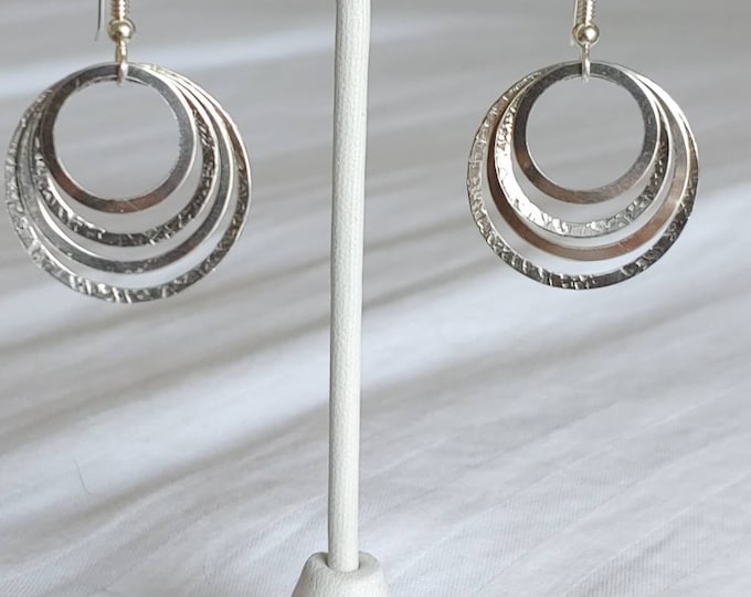 Nesting sterling circles.  Two textured and two satin circles suspended from sterling silver french earwires