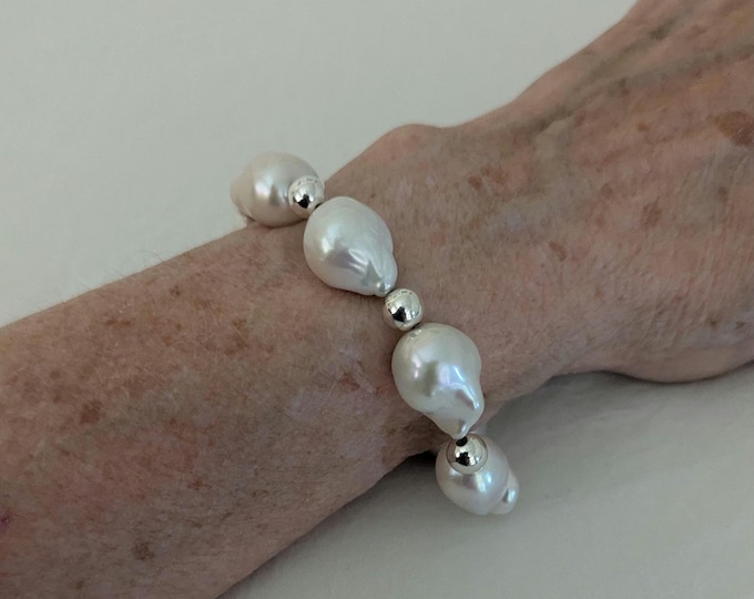 Feel like Audrey Hepburn!!  A+ Baroque high luster pearls and sterling silver beads. It has a subtle figure eight clasp and security chain.