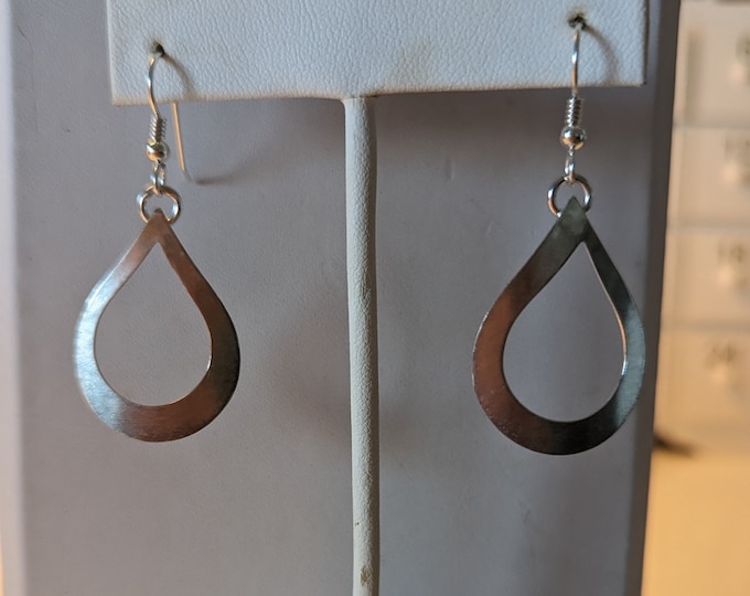 Sterling silver cutout teardrop earrings dangle from french wires.  Slight convex form.