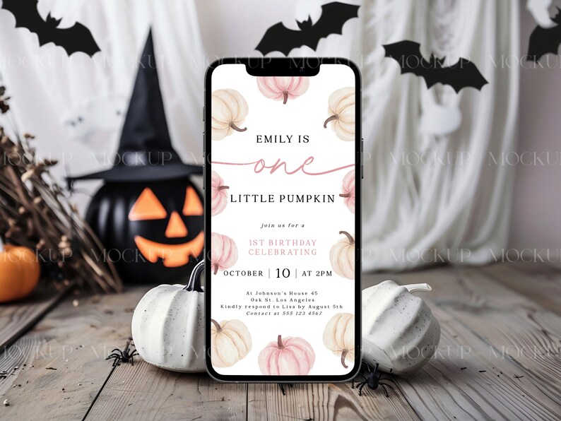 K&ouml;nnte beinhalten: Ein Smartphone zeigt eine Halloween-Einladung mit K&uuml;rbis-Illustrationen und dem Text "Emily is one Little Pumpkin". Das Telefon liegt auf einer Holzoberfl&auml;che mit K&uuml;rbissen, Spinnen und Flederm&auml;usen, was eine festliche Szene ergibt.