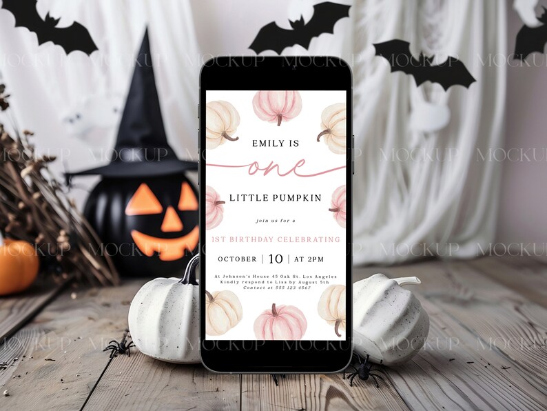 K&ouml;nnte beinhalten: Ein Smartphone zeigt eine Halloween-Einladung mit K&uuml;rbisillustrationen. Die Einladung lautet "Emily is one, Little Pumpkin, 1st Birthday Celebrating October 10 at 2 PM." Die Szene umfasst K&uuml;rbisse, Flederm&auml;use und eine Jack-o'-Laterne.
