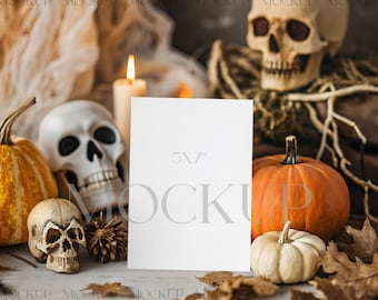 Op de afbeelding: Een Halloween-thema mockup met een blanco kaart van 5x7 inch. De scène bevat pompoenen, schedels, herfstbladeren en een brandende kaars. Het kleurenpalet wordt gedomineerd door oranje, wit en bruin.