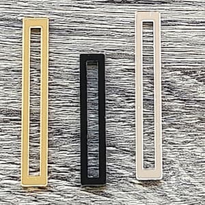 以下が含まれることがあります： 金色、黒色、白色の金属製の長方形のヘアクリップが3つあります