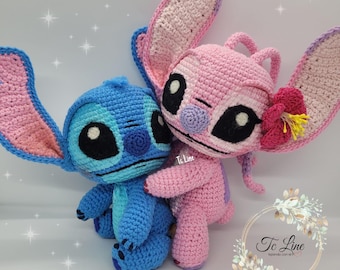 May include: Two crocheted Stitch plush toys, one blue and one pink, with embroidered facial features. The blue Stitch is holding the pink Stitch.
