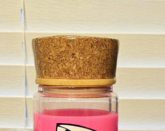 May include: A clear glass jar with a pink interior, topped with a cork lid. The cork lid is cylindrical and has a natural, textured appearance. The jar's contents are visible through the glass.