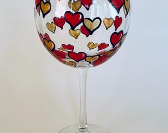 Hand painted wine glass with red and gold hearts.  Made in USA.
