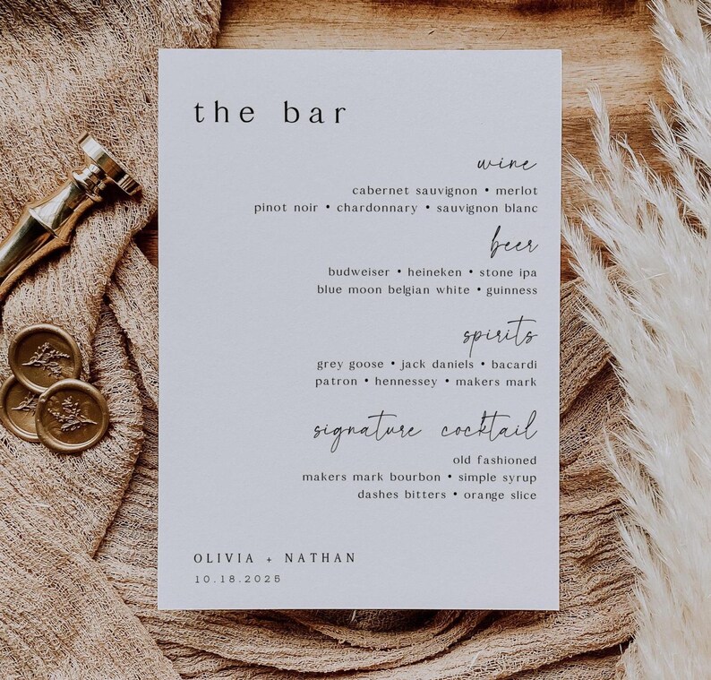 May include: A white rectangular bar menu with the text "the bar" at the top. The menu lists wine, beer, spirits, and signature cocktails. The names Olivia and Nathan are at the bottom, with the date 10.18.2025.