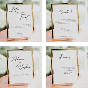 May include: Four gold-framed signs with white backgrounds and black calligraphy. The signs read "Late Night Treat", "Guestbook", "Advice and Wishes", and "Favors".