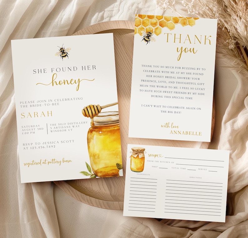 K&ouml;nnte beinhalten: Eine Honig-Motto-Brautduscheinladung mit einer Aquarell-Illustration eines Honigglases und einer Biene. Der Einladungstext lautet "She Found Her Honey" und enth&auml;lt den Namen der Braut, Datum, Uhrzeit und Ort. Die Einladung enth&auml;lt auch eine RSVP-Karte und eine Rezeptkarte.