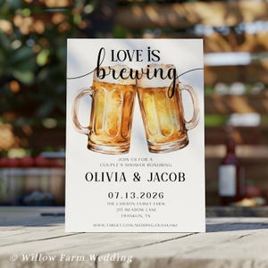 Op de afbeelding: Een trouwuitnodiging met de tekst "LOVE IS brewing" boven twee aquarel bierpullen. De uitnodiging is voor Olivia & Jacob, met de datum 07.13.2026 en locatiegegevens. De onderkant van de uitnodiging luidt "Willow Farm Wedding".