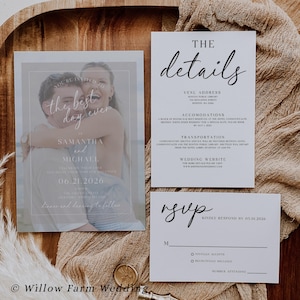 Op de afbeelding: Een trouwuitnodigingsset met een uitnodiging met een foto van een stel, een detailskaart en een RSVP-kaart. De uitnodiging bevat de tekst "You're invited to the best day ever" en de datum 06.21.2026. De set ligt op een houten dienblad.