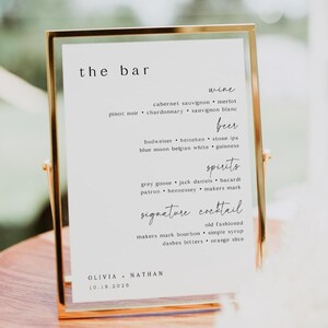 May include: A gold-framed sign with the words "the bar" at the top. The sign lists wine, beer, spirits, and signature cocktail options. The names Olivia and Nathan, along with the date 10.18.2026, are at the bottom.