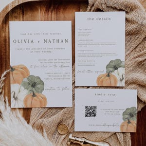May include: Wedding invitation suite featuring a design with watercolor pumpkins in shades of orange, green, and white. The invitation includes the names Olivia and Nathan, wedding details, and RSVP information. The suite is on a white background.