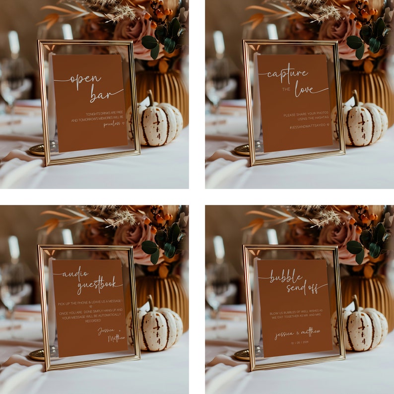May include: Four gold-framed signs with brown paper inserts and white calligraphy. The signs read "open bar", "capture the love", "audio guestbook", and "bubble send off".