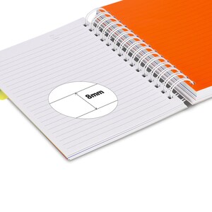 May include: A white spiral bound notebook with lined pages. The notebook is open to reveal a blank page with a circle drawn on it. The circle has a line drawn through it with the text "8mm" written on the line.