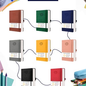 May include: A collection of ten different coloured ruled journals with a gold lion logo on the front cover. The journals are arranged in a grid pattern with a black cord connecting each journal.