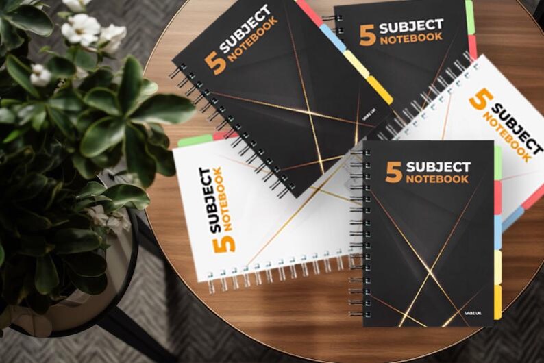 May include: Five subject notebooks with colourful tabs. The notebooks have a black cover with gold lines and the text "5 Subject Notebook" in white and orange.
