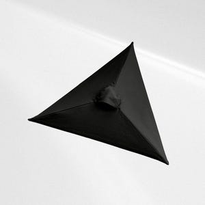 May include: A black, three-dimensional triangular pyramid object with smooth, matte fabric surfaces. The structure features sharp, defined edges meeting at a central apex, with a small, circular, gathered fabric opening located at the center.