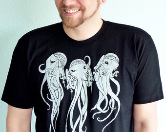 May include: A black t-shirt with a graphic print of three stylized octopus heads with brains. The octopus heads are white and the background is black.