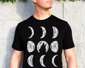 May include: A black t-shirt with a graphic of a wolf howling at the moon. The moon is depicted in various phases, from a crescent to a full moon.