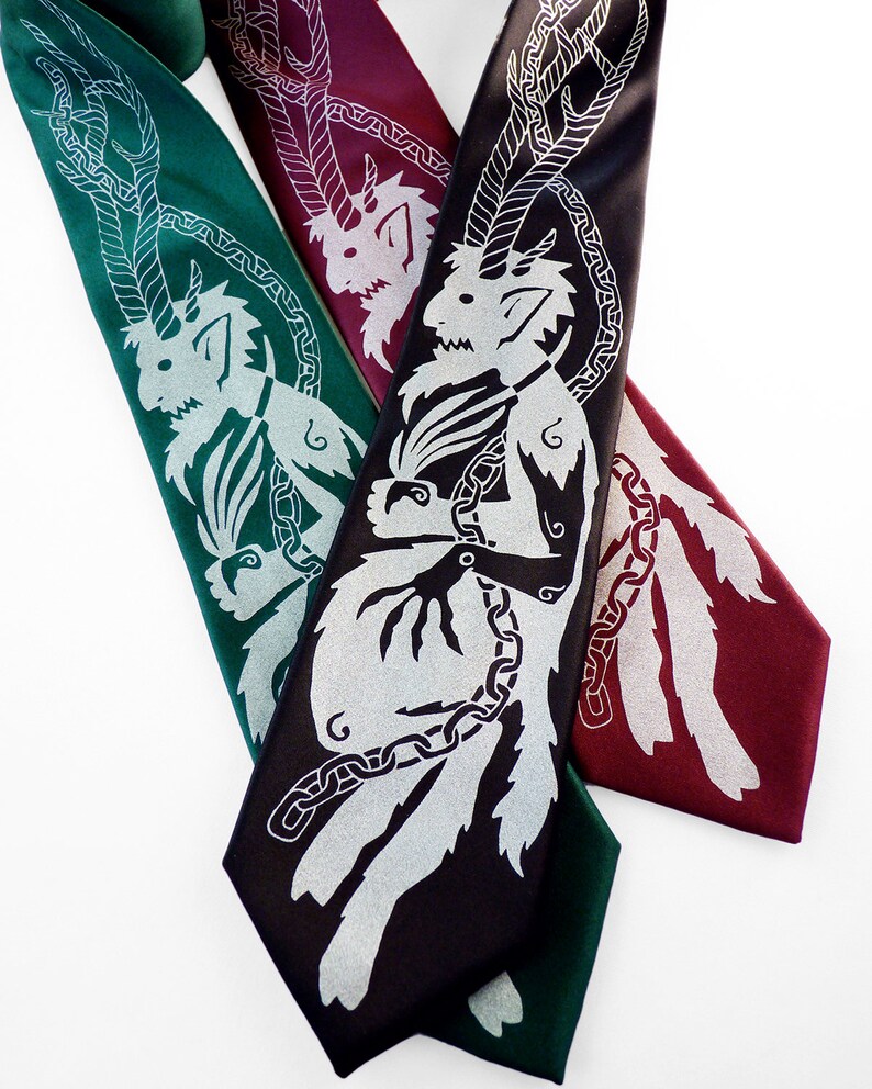 May include: Three neckties in shades of green, burgundy, and black, each featuring a silver mythical creature design. The ties are arranged diagonally, showcasing the intricate details of the artwork. The ties are made of a smooth, shiny material.