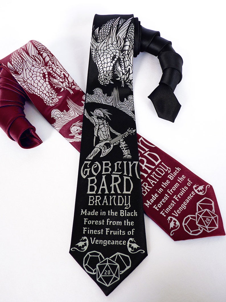 May include: Two neckties with a dragon and a goblin bard design. The black tie has the text "Goblin Bard Brandy Made in the Black Forest from the Finest Fruits of Vengeance" and a 20-sided die. The burgundy tie has the same text and die design.