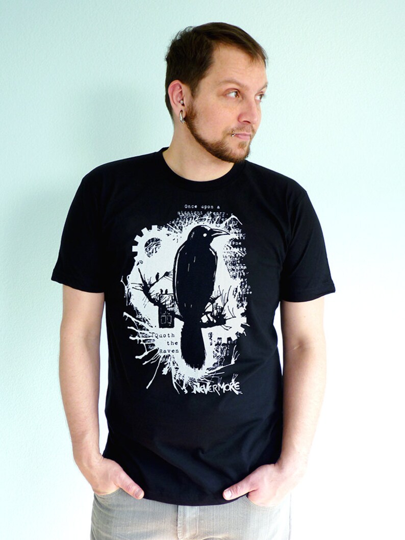 May include: Black t-shirt with a white graphic print of a raven perched on a branch. The graphic includes the text "Once upon a midnight dreary" and "Quoth the Raven, Nevermore".