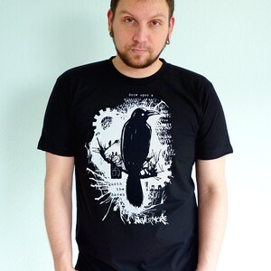 May include: A black t-shirt with a white graphic print of a raven, a tree, and the text "Once upon a midnight dreary... Quoth the raven 'Nevermore'"