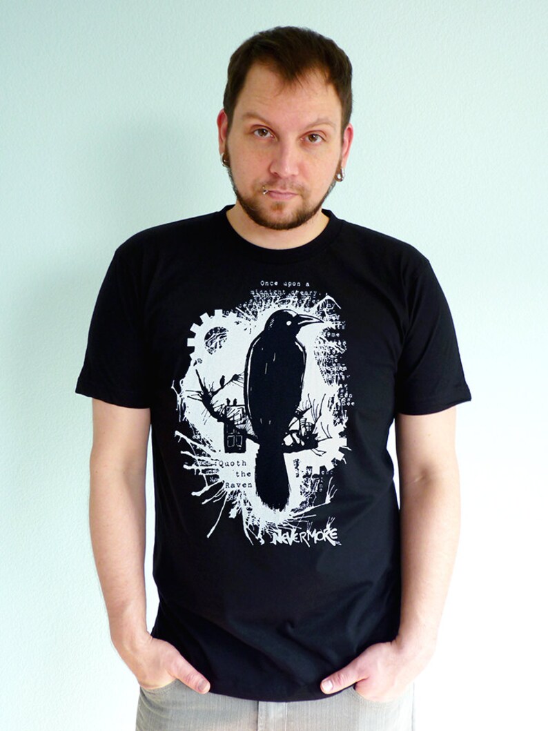 May include: A black t-shirt with a white graphic print of a raven, a tree, and the text "Once upon a midnight dreary... Quoth the raven 'Nevermore'"