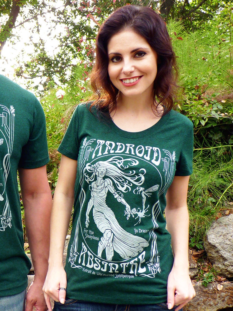May include: Green t-shirt with a white graphic design featuring the word "ANDROID" and the word "ABSINTHE". The design includes an illustration of a woman and the text "For the Sleepless To Dream".