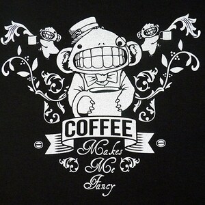 Pu&ograve; includere: Un'illustrazione in bianco e nero di una scimmia dei cartoni animati che tiene una tazza di caff&egrave;. La scimmia indossa un cappello a cilindro e un papillon. Il testo "COFFEE Makes Me Fancy" &egrave; scritto sotto la scimmia.