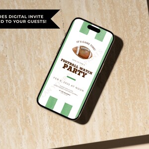 May include: A smartphone displays a digital invitation for a football watch party. The invitation features a watercolor football, green stripes, and the text "FOOTBALL WATCH PARTY" with the date and time. The phone is on a light-colored surface.