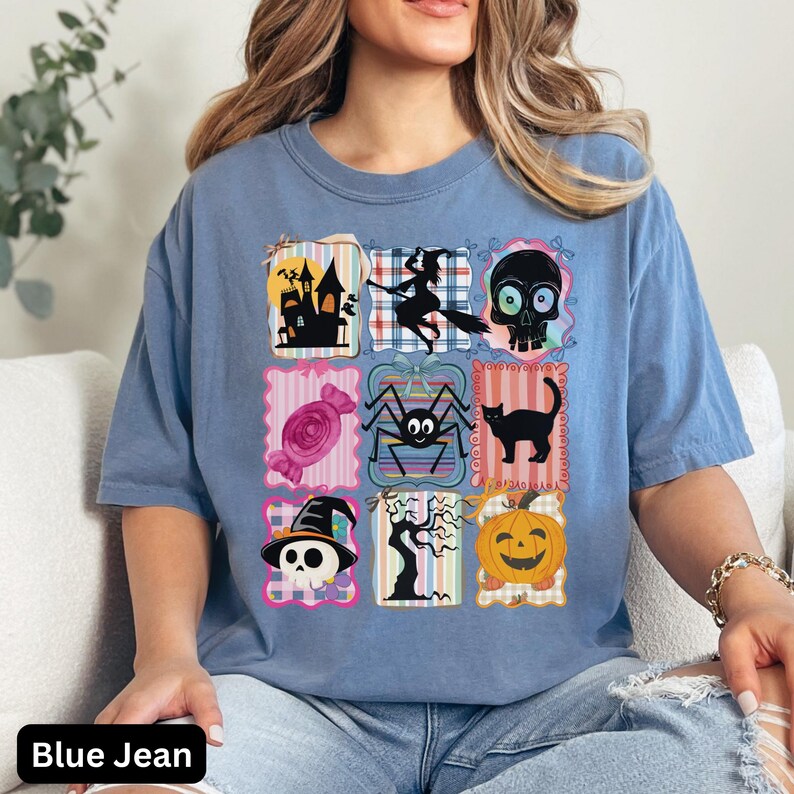 Puede incluir: Camiseta azul vaquero con una cuadr&iacute;cula de gr&aacute;ficos tem&aacute;ticos de Halloween. Los gr&aacute;ficos incluyen una casa embrujada, una bruja en una escoba, una calavera, caramelos, una ara&ntilde;a, un gato negro, una calavera con un sombrero de bruja, un &aacute;rbol espeluznante y una calabaza.