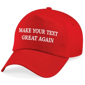 May include: A red baseball cap with a curved brim. The cap features the white text "MAKE YOUR TEXT GREAT AGAIN" across the front. The cap has a button on top and an adjustable strap.