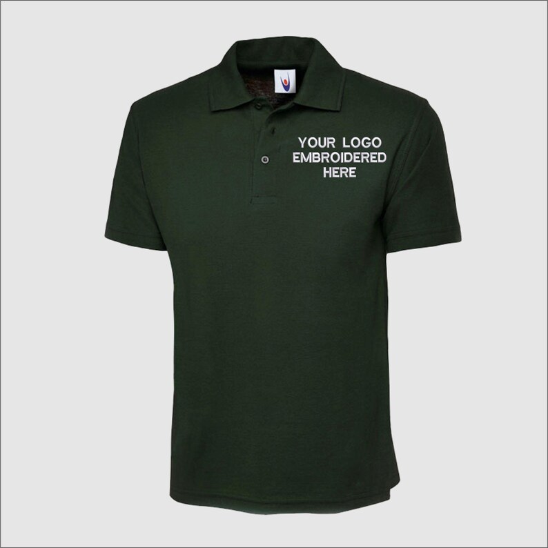 May include: A dark green polo shirt with a white embroidered logo that says "YOUR LOGO EMBROIDERED HERE".