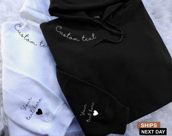 May include: Two hoodies, one white and one black, with the text "Custom text" on the front and "Your text here" with a heart on the sleeve.