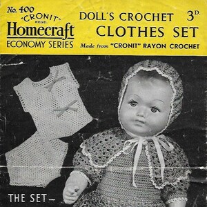 May include: A vintage crochet doll clothes pattern booklet with a black and white photo of a doll wearing a crocheted dress, cape, bonnet, slippers, vest, and knickers. The pattern is titled "Doll's Crochet Clothes Set" and is made from "Cronit" rayon crochet. The booklet is numbered 400.