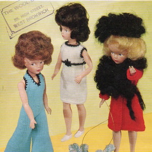 May include: A knitting pattern for a 12-inch doll outfit. The pattern is for a blue jumpsuit, a white dress with black trim, and a red dress with a black fur collar. The pattern is from Sirdar and is number 2369. The pattern costs 9d.