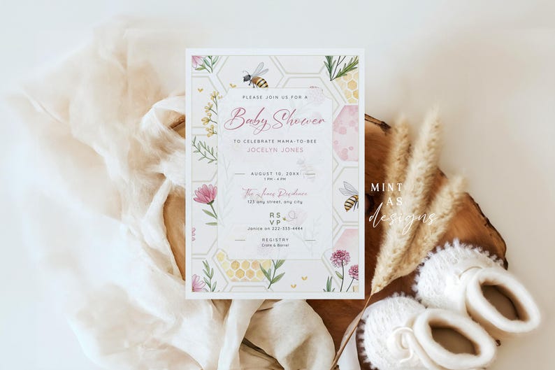 May include: A baby shower invitation with a bee theme. The invitation features a floral and honeycomb design with the text "Baby Shower" and event details. The invitation is surrounded by decorative elements including flowers, bees, and baby shoes.