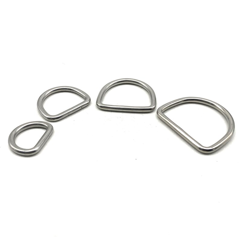 Op de afbeelding: Vier zilveren metalen D-ringen in verschillende maten. De ringen zijn glad en glanzend.
