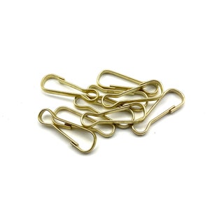 Op de afbeelding: Een groep gouden metalen sleutelringen met een draaibare sluiting. De sleutelringen liggen op een witte achtergrond.