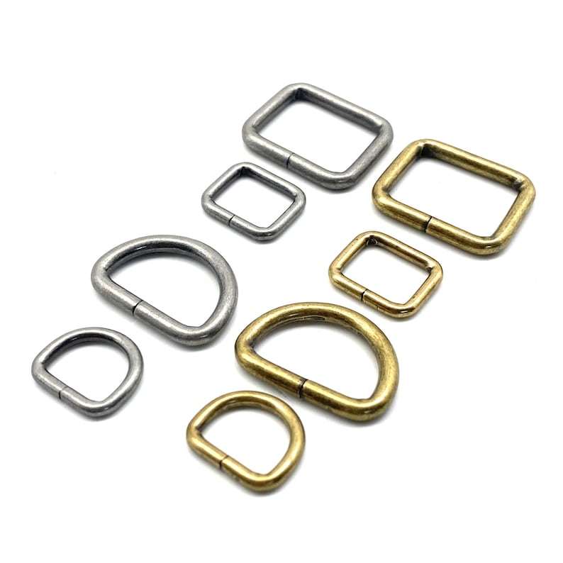 Op de afbeelding: Assortiment van zilveren en gouden metalen D-ringen en vierkante ringen. De ringen zijn in verschillende maten.