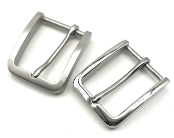 May include: Two silver metal belt buckles. The buckles are rectangular with a smooth, polished finish. The buckles are designed to be used with a belt strap.