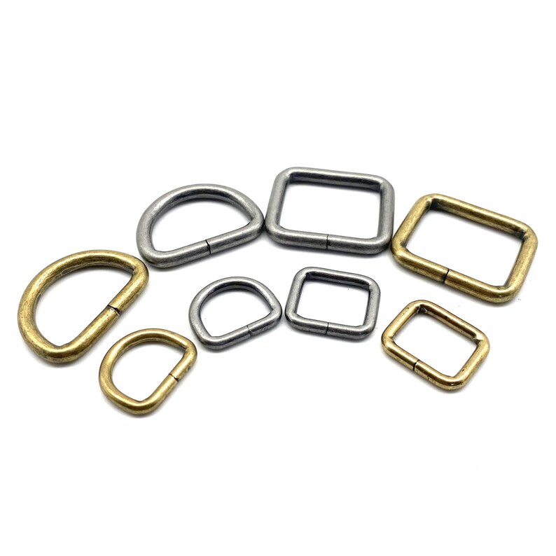 Op de afbeelding: Assortiment van metalen D-ringen en vierkante ringen in gouden en zilveren tinten. De ringen zijn in verschillende maten.