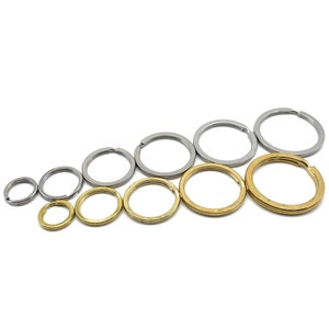 Pode incluir: Conjunto de argolas de chave prateadas e douradas de vários tamanhos. As argolas de chave estão dispostas em diagonal, da menor para a maior.